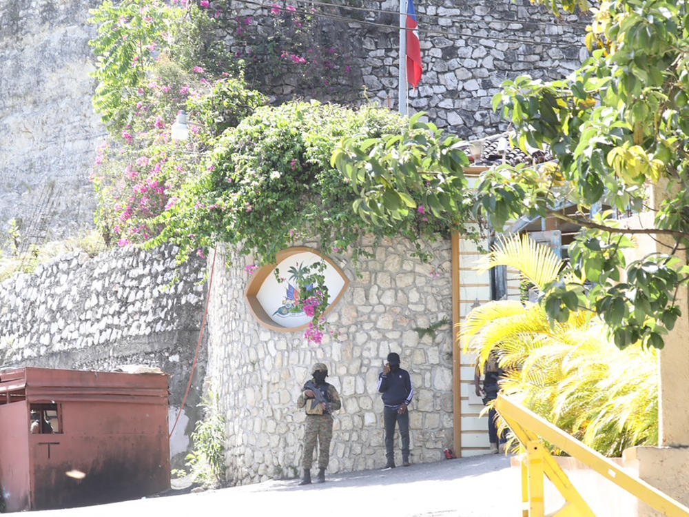 Members of the Haitian police and forensics patrol the area Wednesday as they look for evidence outside  the presidential residence in Port-au-Prince, Haiti.