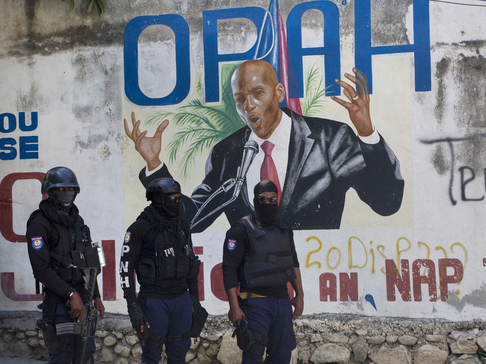 Police stand near a mural featuring Haitian President Jovenel Moïse near the leader's residence, where he was killed by gunmen in the early morning hours in Port-au-Prince, Haiti, on Wednesday.