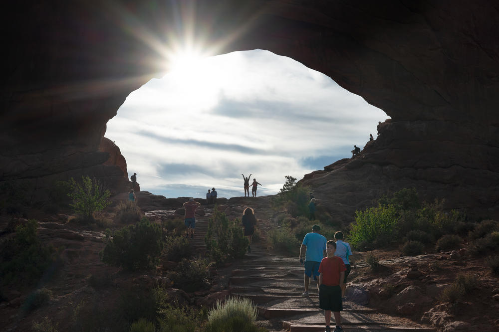 Before 8 a.m., people are already coming in waves to visit North Window Arch in Arches National Park in June.