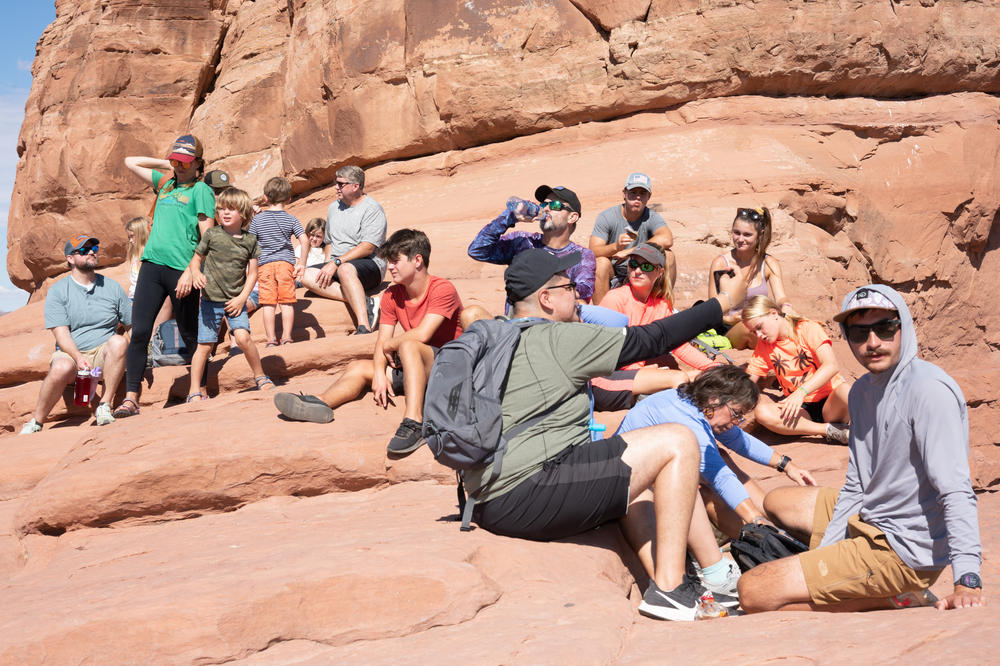 A crowd sits near Delicate Arch in June at Arches National Park.