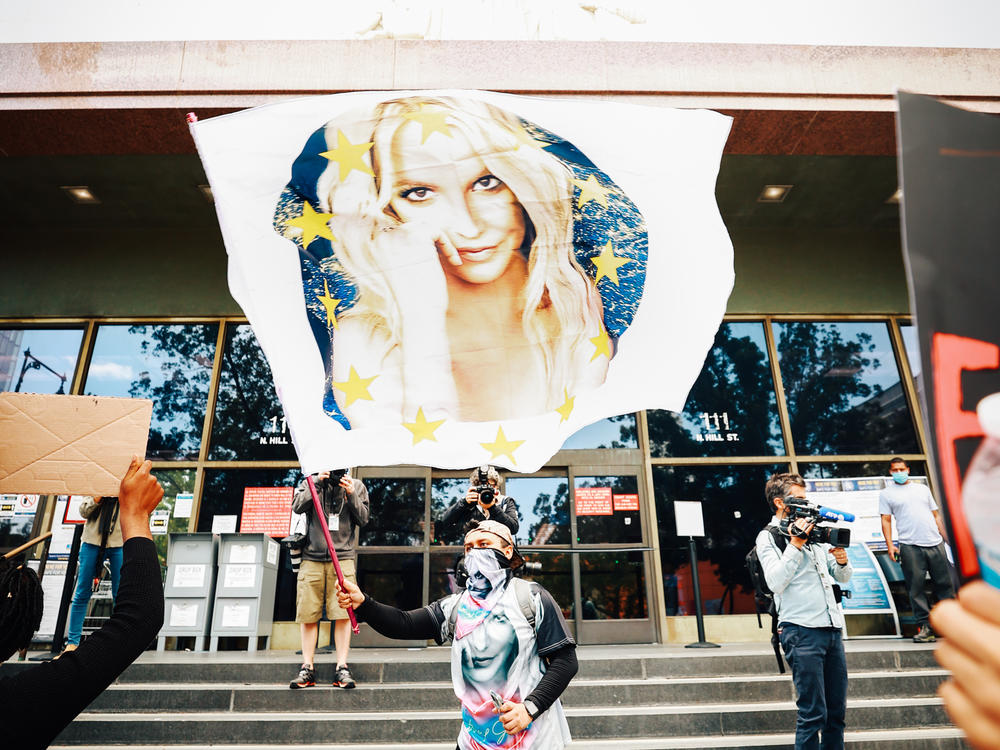 A #FreeBritney protestor flies a Britney flag outside a Los Angeles courthouse. The superstar's conservatorship case has another hearing July 14.