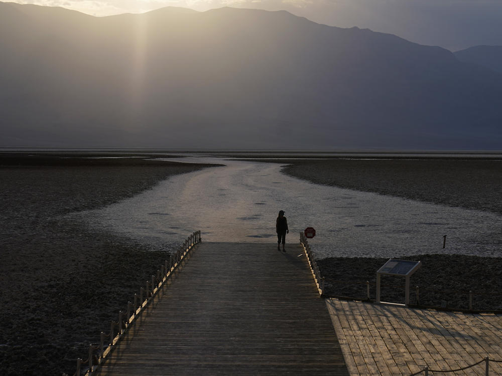 A person walks on a boardwalk at the salt flats at Badwater Basin on Aug. 17, 2020, in Death Valley National Park in California. Temperatures reached 130 degrees there on Friday.