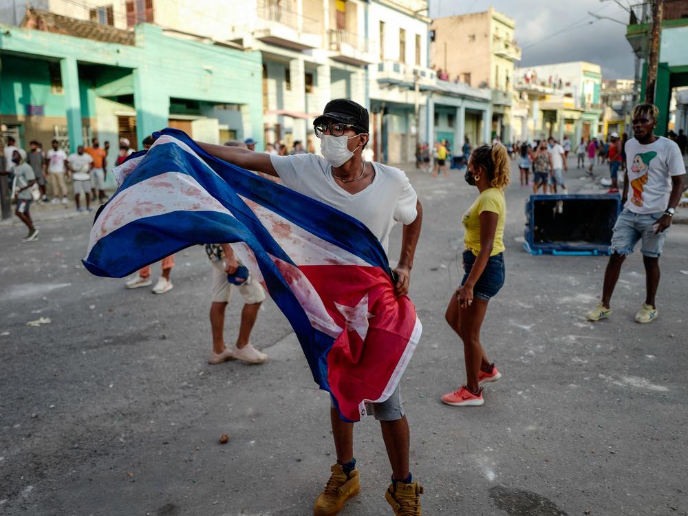 A man waves a Cuban flag during a demonstration against Cuban President Miguel Díaz-Canel's government Sunday in Havana as large numbers take part in rare protests against the communist regime.