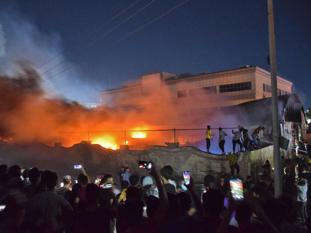 People gather as a massive fire engulfs the coronavirus isolation ward of al-Hussein hospital in the southern Iraqi city of Nasiriyah, late on Monday.