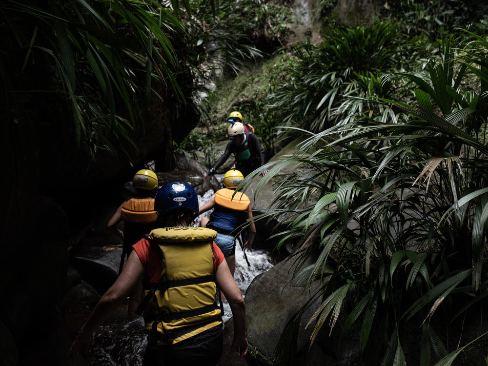While rafting down the Guejar River, tourists stop to hike along a stream to a waterfall near the town of Mesetas, which used to be under FARC rebel control in southern Colombia.