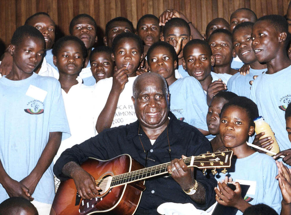 Former Zambian President Kenneth Kaunda plays the guitar at a workshop in Lusaka on November 10, 2000. He used his music to send messages, including how to combat AIDS.