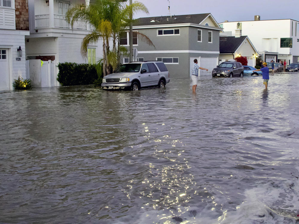 Streets and homes flooded in Newport Beach, Calif., during a high tide in July 2020. So-called sunny day floods are getting more common in coastal cities and towns as sea levels rise due to climate change.