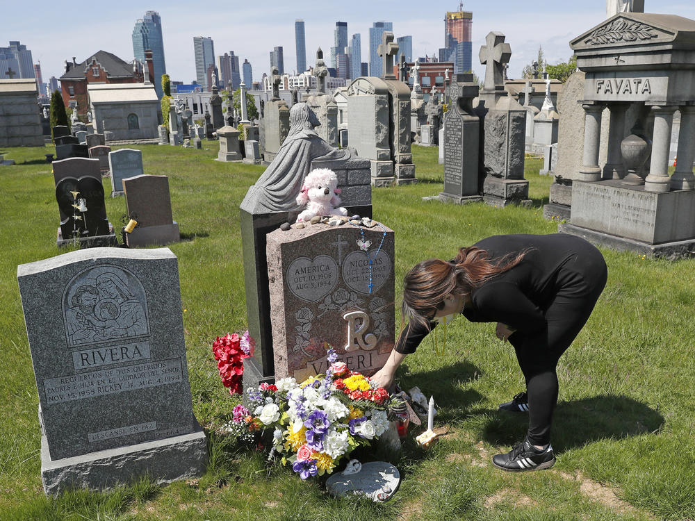 Sharon Rivera adjusts flowers at daughter Victoria's grave at Calvary Cemetery in New York City in 2020. Her daughter, 21, died of a drug overdose in 2019. According to new CDC data, drug overdose deaths soared to more than 93,000 last year.