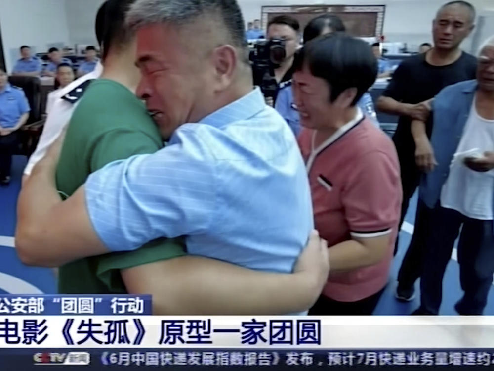 Guo Gangtang, right, embraces his son Guo Xinzhen during a reunion after 24 years in Liaocheng, in Central China's Shandong province.