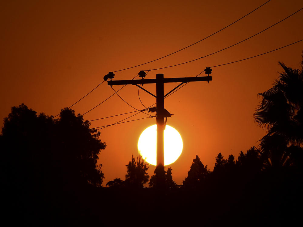 The sun sets behind power lines in Los Angeles in September.