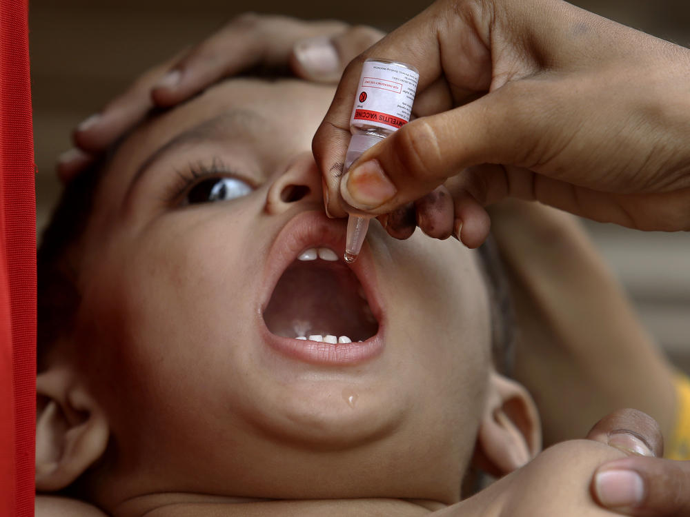 A health worker administers a polio vaccine to a child in Karachi, Pakistan, on June 9.