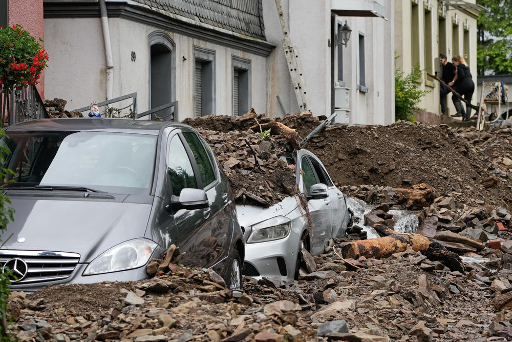 Cars are covered with debris brought on by flooding from a nearby river on Thursday in Hagen, Germany.