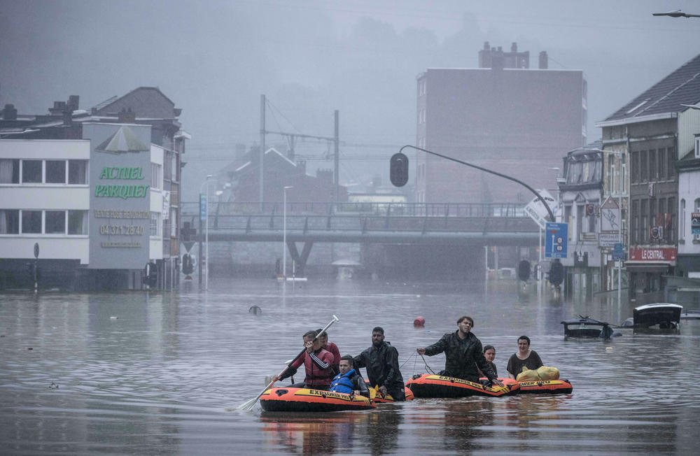 People use rubber rafts in floodwaters after the Meuse River broke its banks during heavy flooding Thursday in Liège, Belgium.