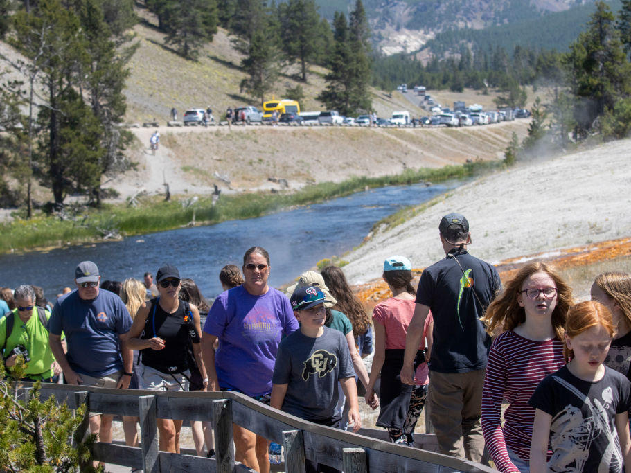Tourists crowd in to the Midway Geyser Basin on July 14, at Yellowstone National Park in Wyoming. Yellowstone is one of many national parks seeing record numbers of visitors this summer, even as coronavirus cases are rising in many states.