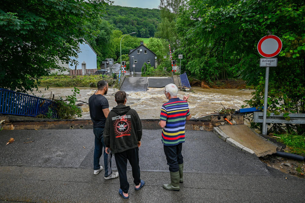 People check out a destroyed railway crossing and other damage caused by flooding from the Volme River on Thursday in Priorei, Germany, near Hagen.