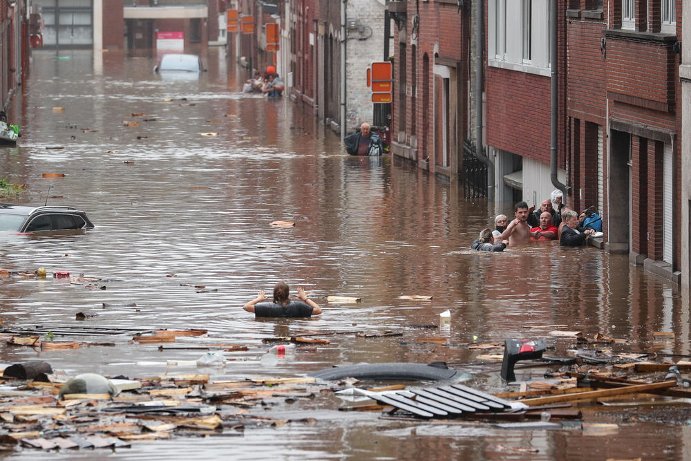 A woman tries to move in a flooded street following heavy rains Thursday in Liège, Belgium.