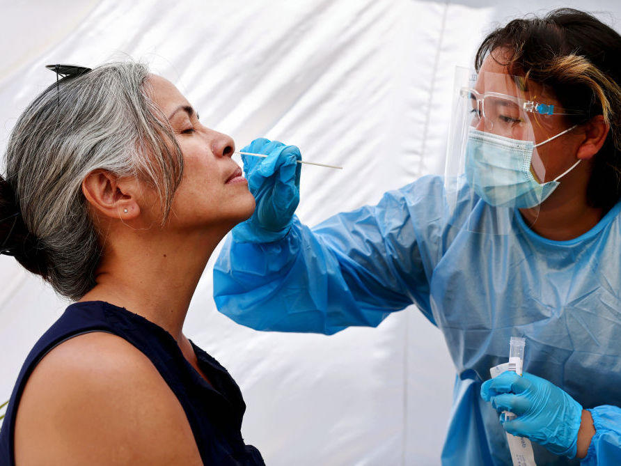 A medical assistant administers a COVID-19 test to a person at Sameday Testing this week in Los Angeles.