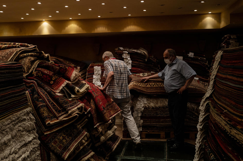 Ferudun Ozgumus (left) walks through a carpet shop above a basement containing Byzantine-era ruins.