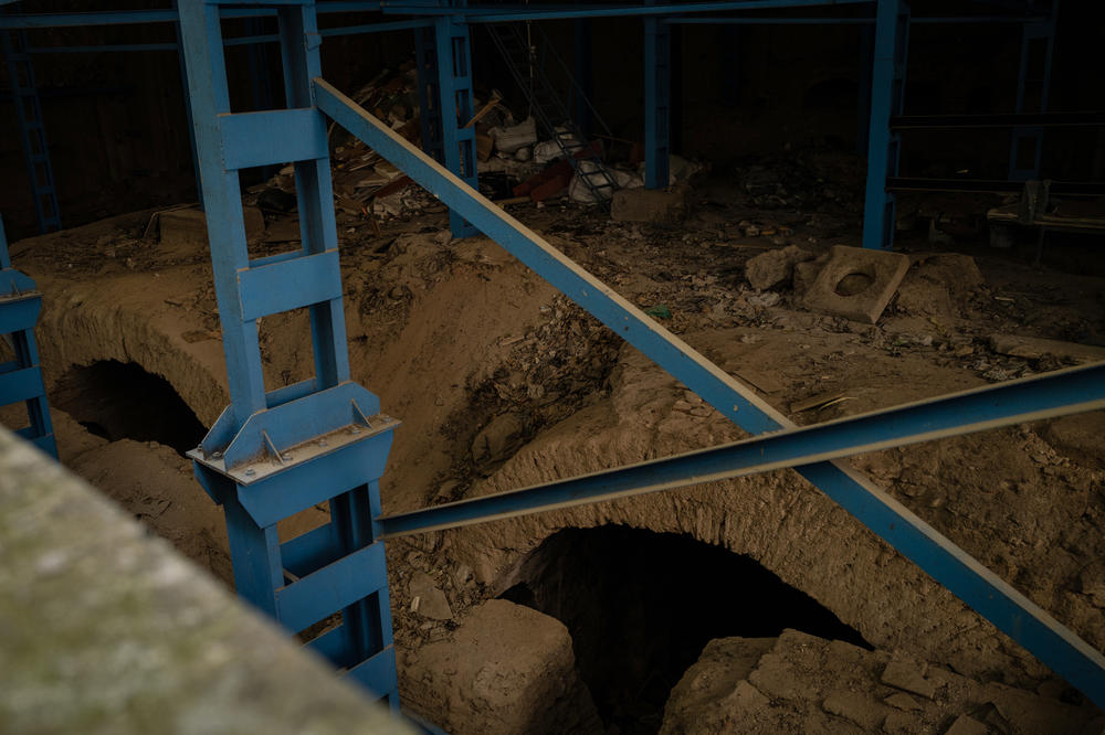 Scaffolding is attached to 6th century archways surrounded by garbage.