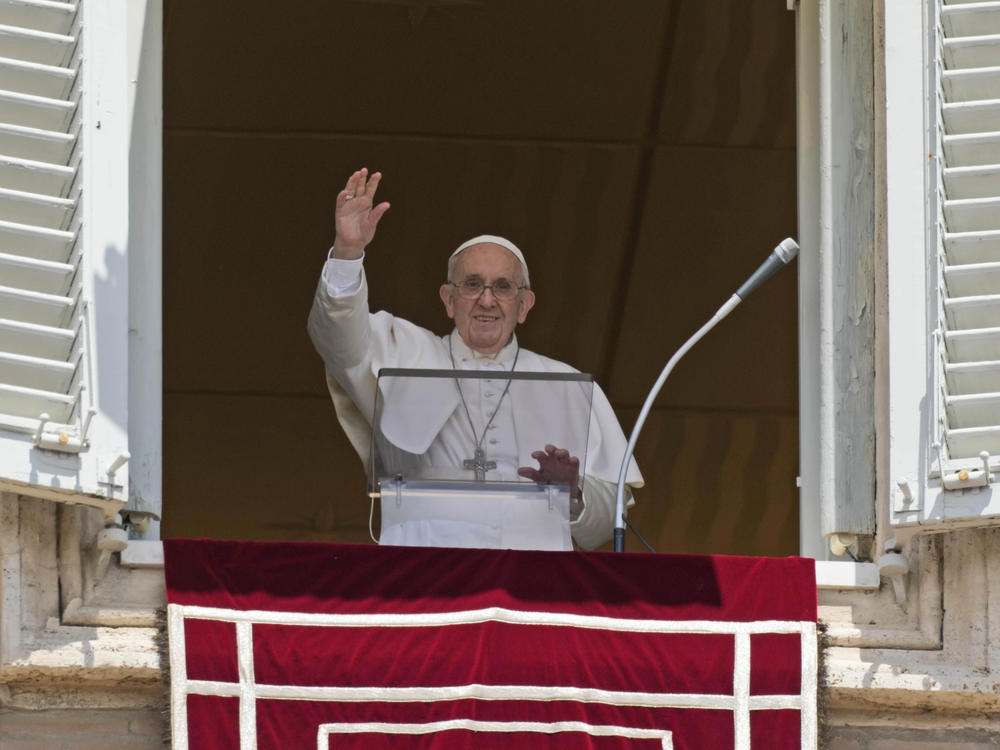 Pope Francis salutes the crowd as he arrives for the Angelus noon prayer from the window of his studio overlooking St. Peter's Square at the Vatican on Sunday.