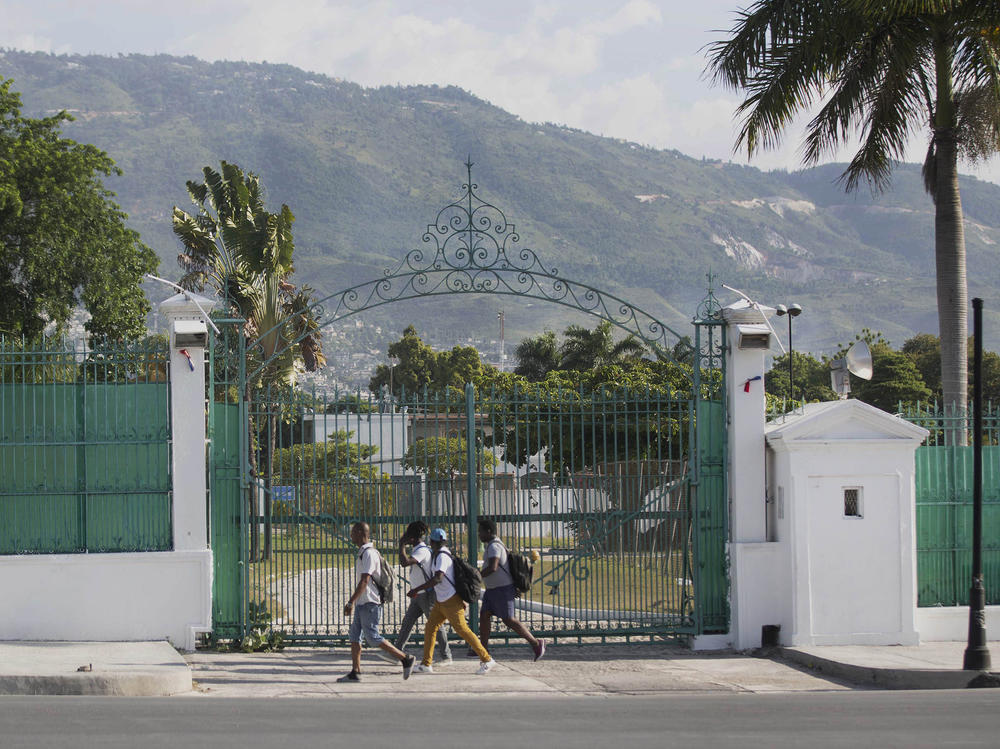 Pedestrians walk past the National Palace in Port-au-Prince, Haiti, Wednesday, July 7, 2021. A squad of gunmen assassinated Haitian President Jovenel Moise and wounded his wife in an overnight raid on their home Wednesday(AP Photo/Joseph Odelyn)