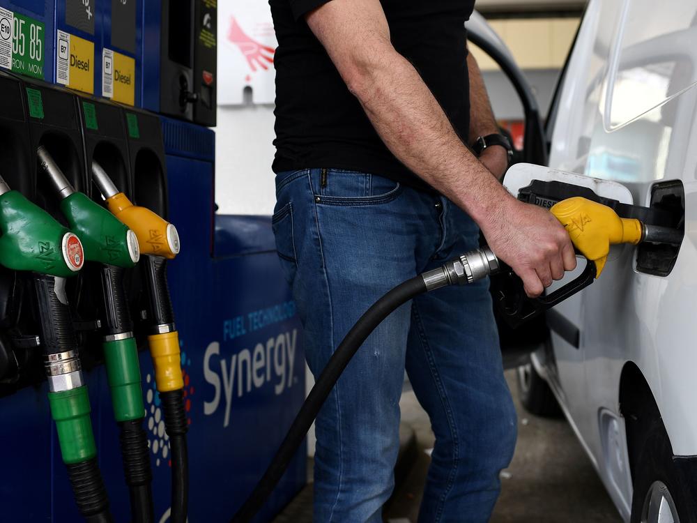 A man refuels his car in Paris in 2020. Men spend their money on greenhouse gas-emitting goods and services at a much higher rate than women, researchers found.