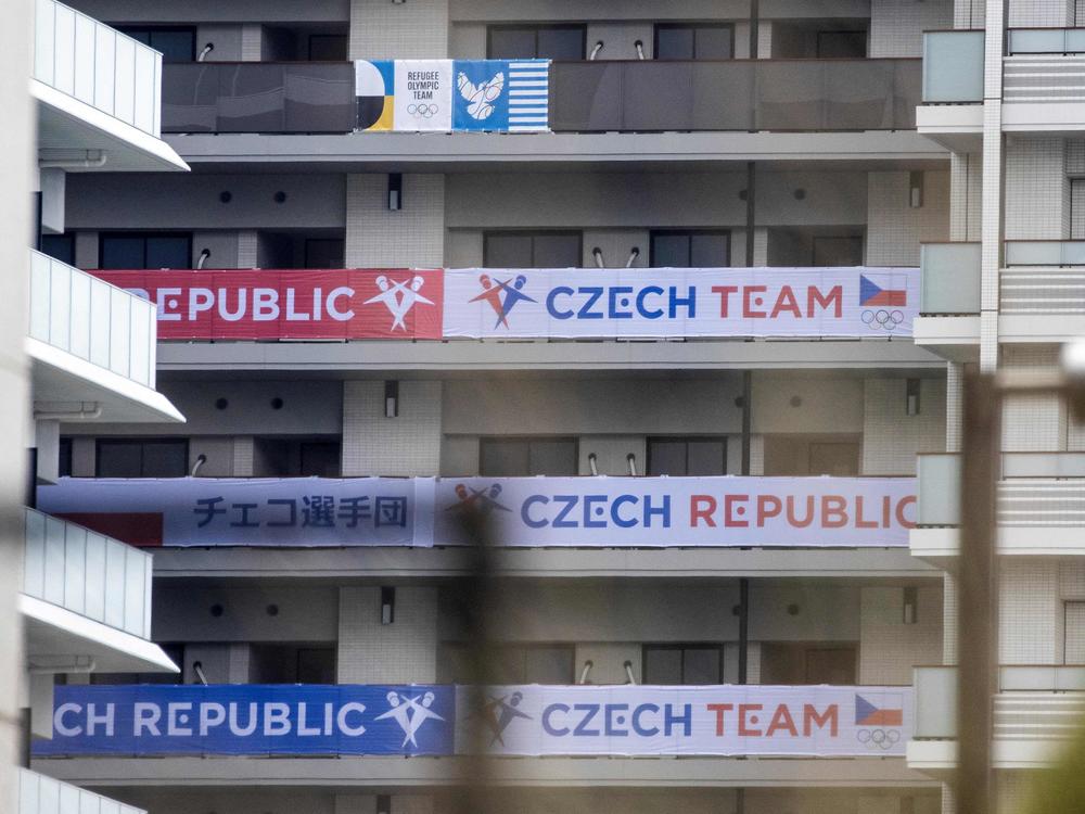 Banners of the Czech Republic (bottom) and the Olympic Refugee teams (top) are seen on a building at the Olympic and Paralympic Village ahead of the 2020 Tokyo Olympics. The Czech team is investigating a cluster of coronavirus cases.