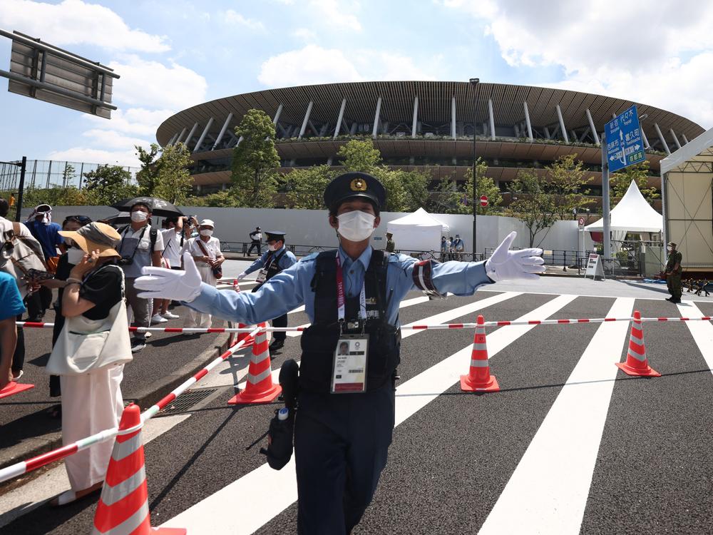 Police manage the crowd outside the Olympic Stadium in Tokyo on July 23, 2021, ahead of the opening ceremony of the 2020 Tokyo Olympic Games.