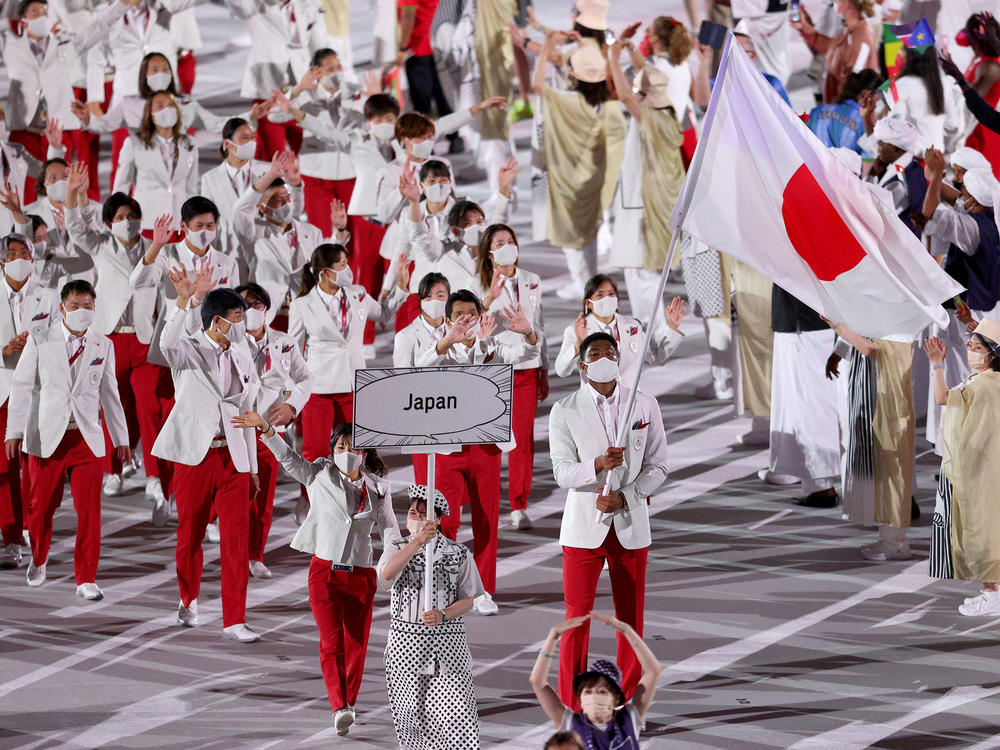 Flag bearers Yui Susaki and Rui Hachimura of Team Japan lead their team.