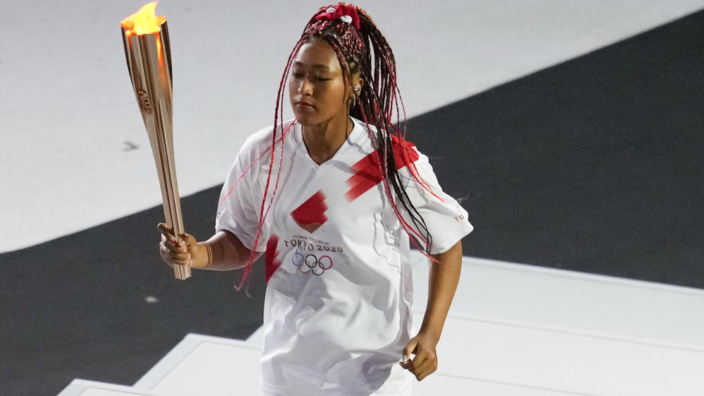 Tennis star Naomi Osaka carries the Olympic torch to light the cauldron at the opening ceremony of the Tokyo Olympics.