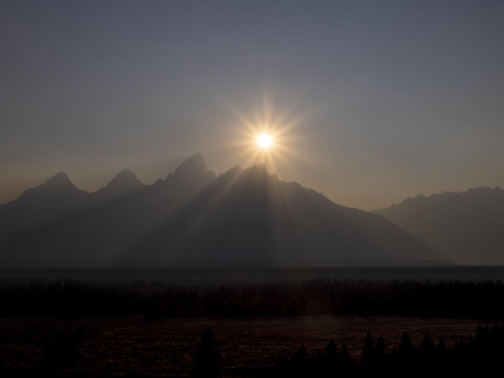 A peak is shrouded in smoke from regional wildfires on July 14, at Grand Teton National Park, south of Yellowstone.