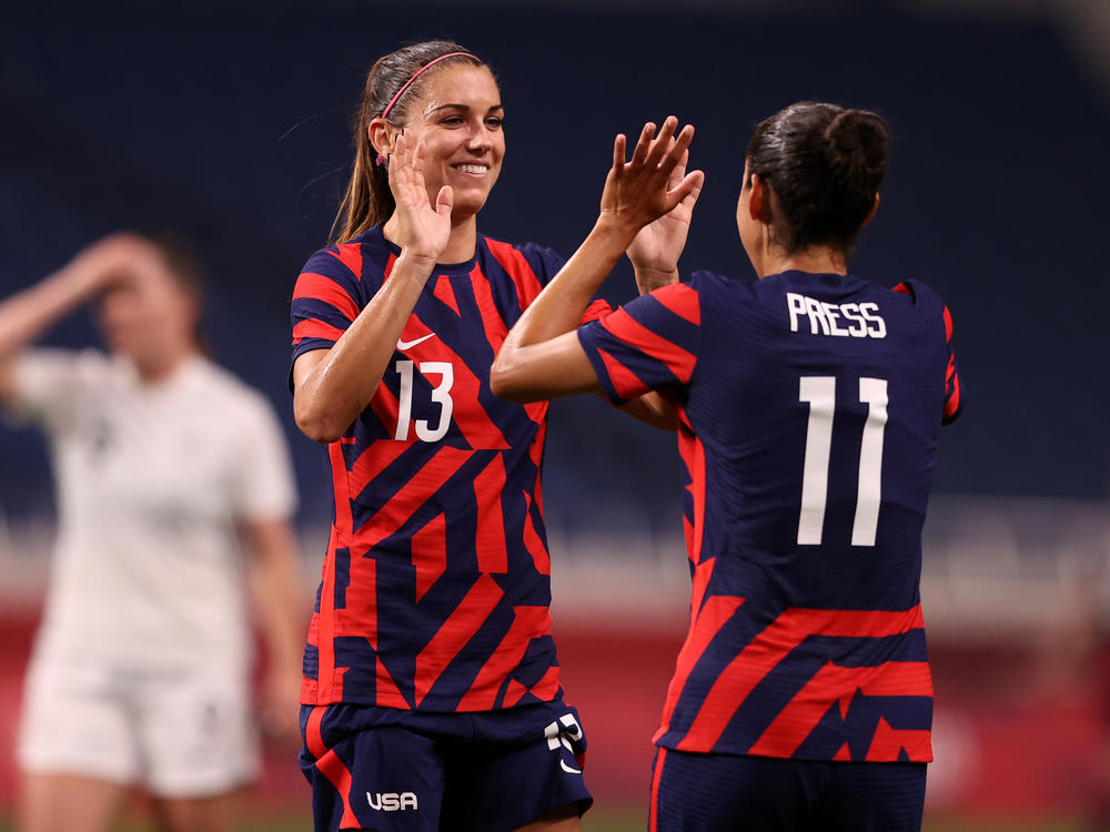 Alex Morgan (#13) celebrates another Team USA goal against New Zealand with teammate Christen Press (#11) at the Tokyo Olympics on Saturday in Saitama, Japan.