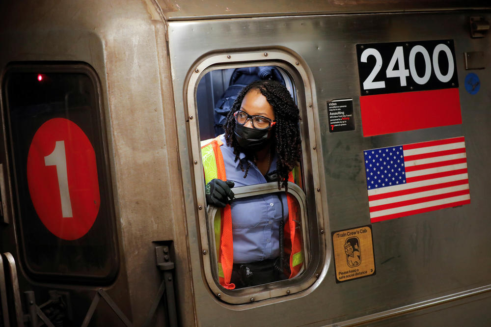 An MTA worker wears a protective mask while working on a subway train in New York City on Monday as coronavirus cases continue to rise, fueled by the virus's delta variant.