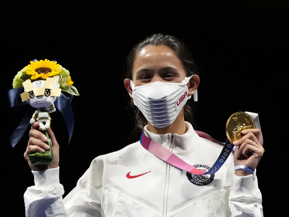 Gold medalist Lee Kiefer of the United States shows her medal and victory bouquet during the medal ceremony for the women's individual foil final competition on Sunday at the Summer Olympics.