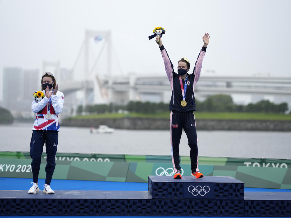 Gold medal winner Flora Duffy of Bermuda (center) celebrates her win in the triathlon on Tuesday, next to silver medalist Georgia Taylor-Brown of Great Britain.