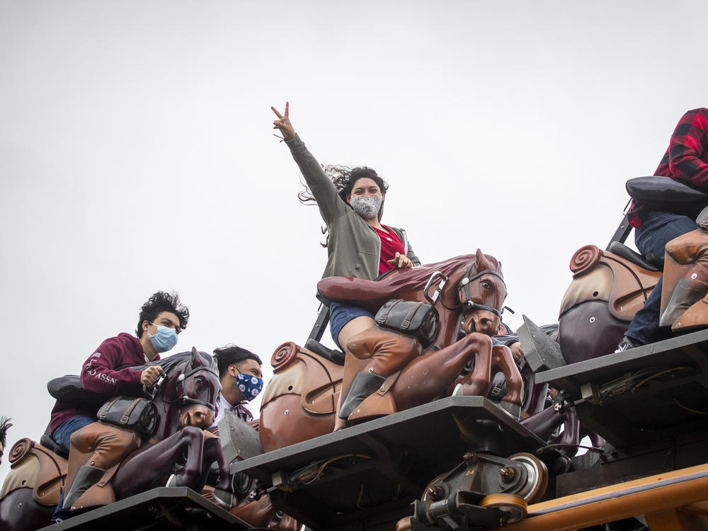 To mask or not to mask: That is the question for vaccinated people as the delta variant surges. The answer may depend on the situation, experts say. Here, these roller-coaster riders mask up at Knott's Berry Farm in Buena Park, Calif.