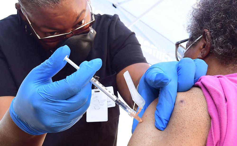 Vocational nurse Eon Walk administers the Pfizer COVID-19 vaccine at a mobile vaccine clinic operated by the Los Angeles County of Public Health earlier this month in Los Angeles.