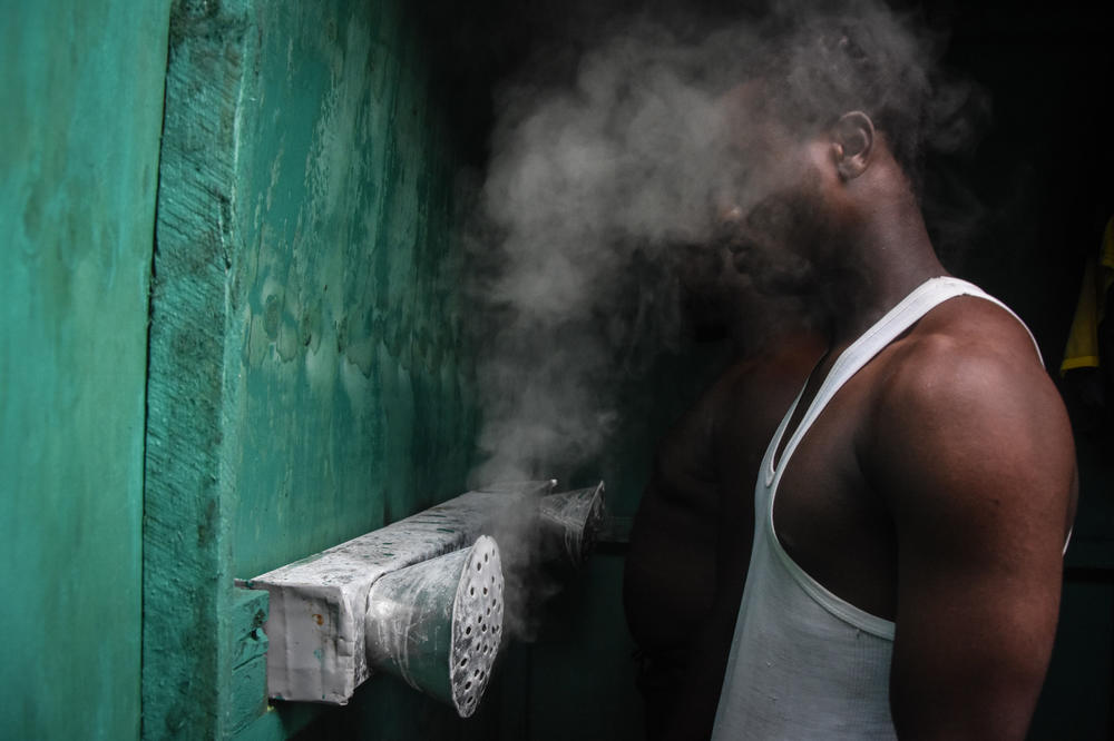Tanzania is now endorsing COVID-19 vaccines. But for many months, its leaders said that vapors could prevent the disease. Above: A man inhales at a booth installed by an herbalist in Dar es Salaam.