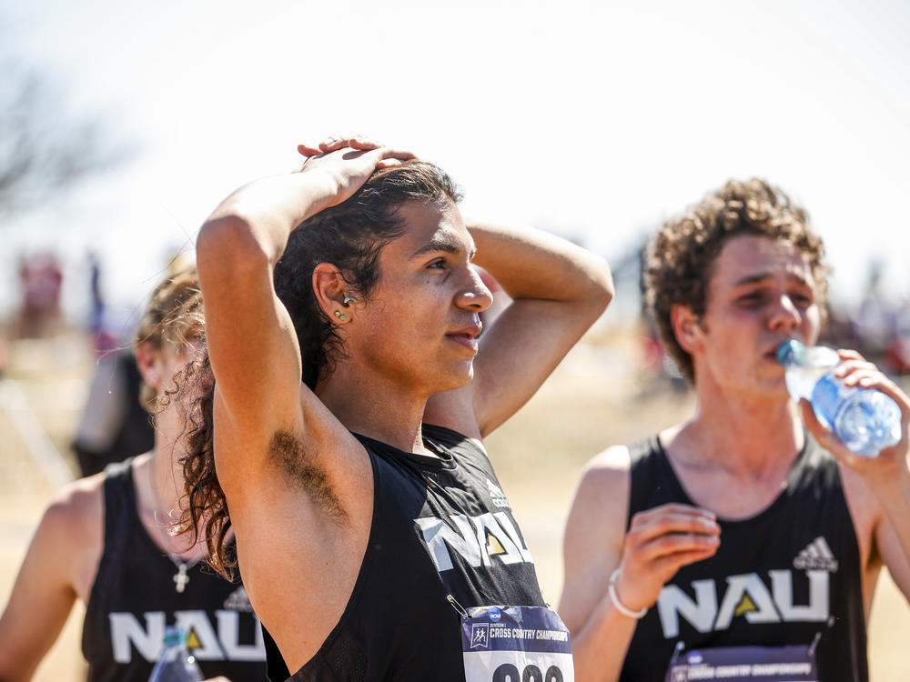 Luis Grijalva relaxes with his Northern Arizona University teammates after winning the team championship at the Division I Men's and Women's Cross Country Championships on March 15 in Stillwater, Okla.