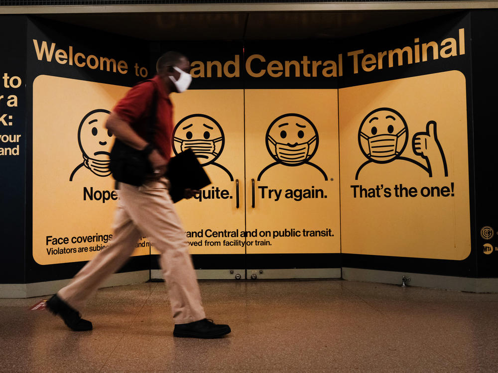 A person wears a mask while walking at Grand Central Terminal on July 27 in New York City. Masks continue to be required at many places despite the rollout of vaccines. The Centers for Disease Control and Prevention this week recommended that fully vaccinated people begin wearing masks indoors again in places with high coronavirus transmission rates.