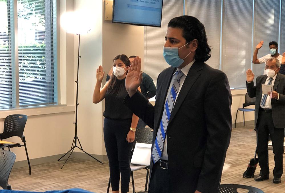 Janis Shinwari takes his oath as a naturalized U.S. citizen in a ceremony in Fairfax, Va., on June 30, 2020. He worked eight years as an Afghan interpreter with the U.S. military in his homeland, and was credited with saving the lives of five U.S. troops. Many other former Afghan interpreters are still awaiting visas to come to the U.S.