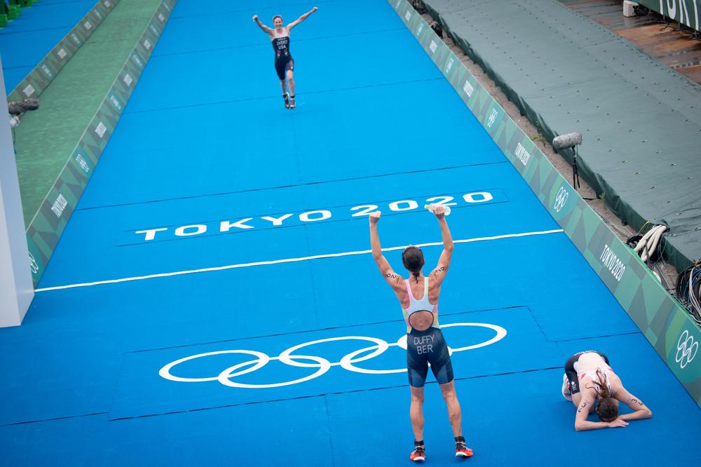 Winner Bermuda's Flora Duffy, center, third-placed U.S.'s Katie Zaferes, top left, and second-placed Britain's Georgia Taylor-Brown, right, react after completing the women's individual triathlon competition on July 27, 2021.