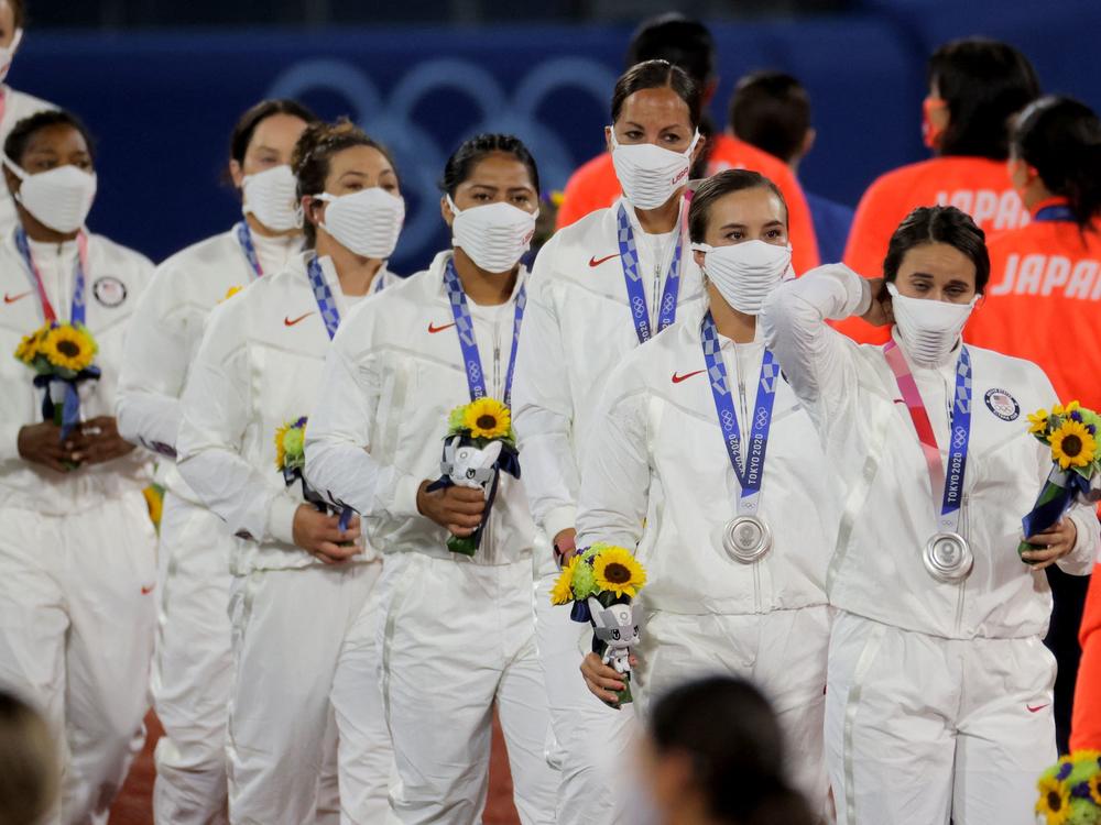U.S. softball players wear their masks after collecting their silver medals.