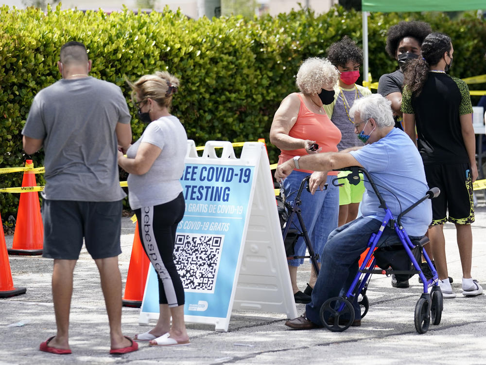 People wait in line at a Miami-Dade County COVID-19 testing site, Monday, July 26, 2021, in Hialeah, Fla. Florida accounted for a fifth of the nation's new infections last week, more than any other state, according to the CDC.