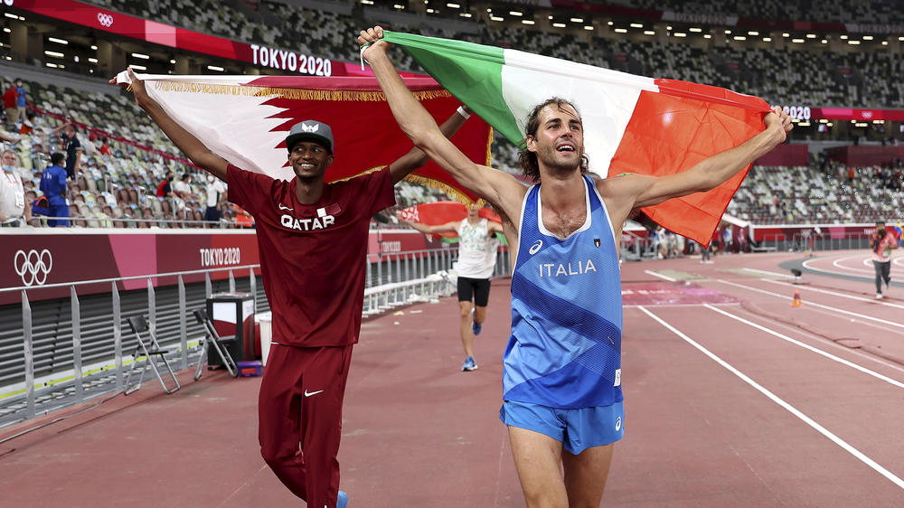 Gold medalists Mutaz Essa Barshim (left) of Qatar and Gianmarco Tamberi of Italy celebrate on the track Sunday.