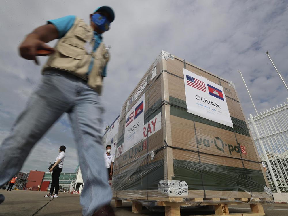 A man walks past donated Johnson & Johnson vaccines after their arrival at the Phnom Penh International Airport in Cambodia on July 30 — the first batch of 1 million shots.