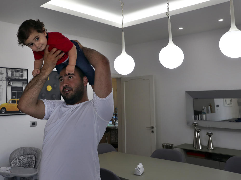 Edmond Khnaisser holds up his son George at home in the town of Jal el-Dib, north of Beirut, on July 10. Khnaisser's wife Emmanuelle was in labor when the Aug. 4, 2020, blast tore through the hospital where George was delivered.