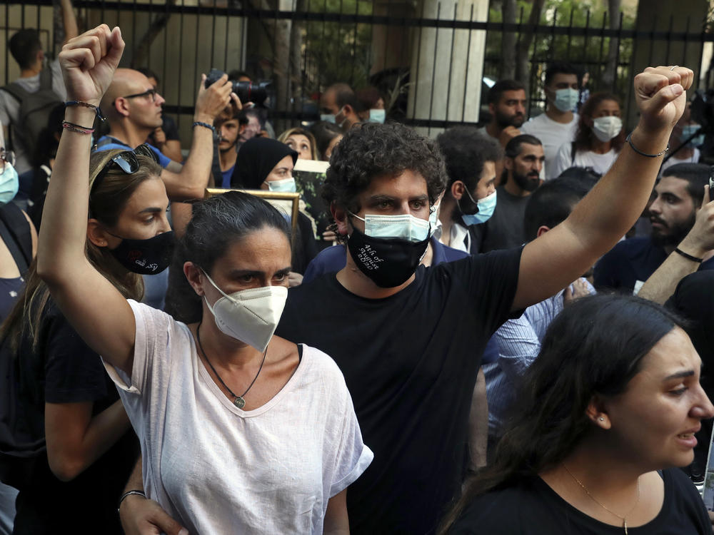 Tracy and Paul Naggear, the parents of 3-year-old Alexandra, who was killed in last year's massive blast, raise their fists during a protest outside the home of caretaker Interior Minister Mohamed Fehmi, in Beirut, July 13. A year after the deadly blast, families of the victims are seeking justice for their loved ones.
