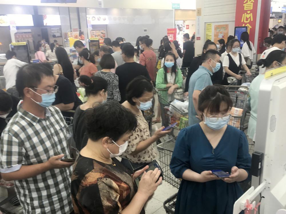 Shoppers turn out heavily Monday at a supermarket in Wuhan, China, after nearby residential blocks went into lockdown as part of COVID-19 prevention measures.