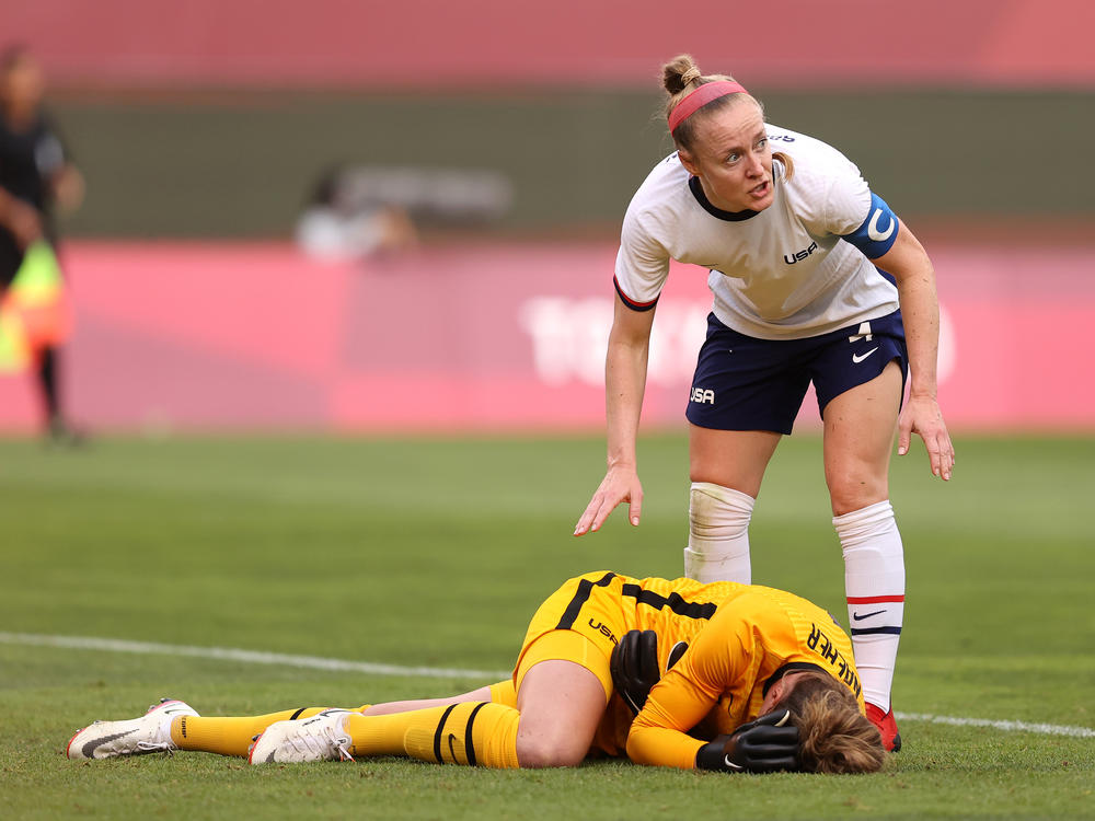 U.S. goalkeeper Alyssa Naeher lies injured as Becky Sauerbrunn checks on her during the women's semifinal match between Team USA and Canada on Monday at the Tokyo Olympic Games at Kashima Stadium.